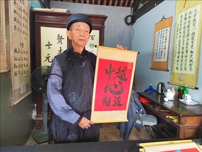 越南首都河內(nèi)文廟內(nèi)，阮明珠展示“中越心相近”書(shū)法作品。
