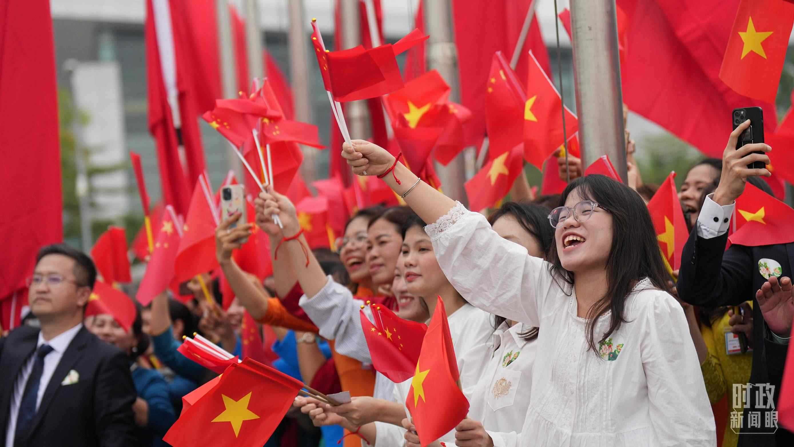 △人們揮舞兩國旗幟歡迎習(xí)近平訪越。（總臺(tái)國廣記者李晉拍攝）