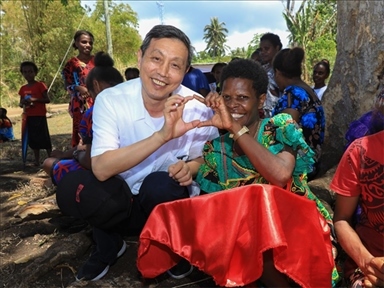 2023年12月18日，中國駐瓦努阿圖大使李名剛和前來觀看瓦努阿圖公路項目二期馬勒庫拉段移交儀式的當地居民合影。人民網 賀吉攝