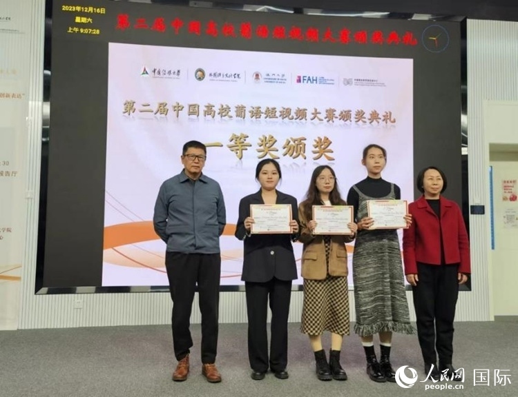 澳門大學(xué)中葡雙語教學(xué)暨培訓(xùn)中心主任姚京明（左一）和中國傳媒大學(xué)外國語言文化學(xué)院院長文春英（右一）為一等獎獲得者頒獎。人民網(wǎng)記者 魯揚(yáng)攝