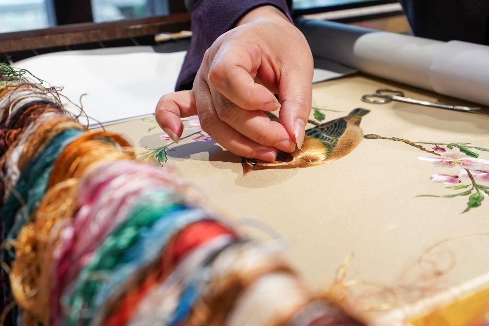 △2023年7月6日，盧建英在江蘇蘇州平江路的工作室內(nèi)刺繡。