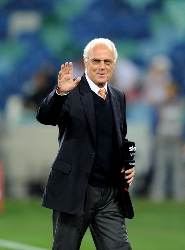 這是2010年7月7日，在南非德班舉行的2010年足球世界杯德國隊對陣西班牙隊的半決賽前，貝肯鮑爾接受電視臺采訪時和友人打招呼。新華社記者 王毓國 攝