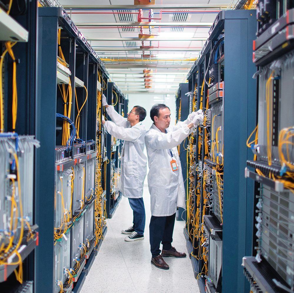 在位于武漢中國光谷的光電器件研發(fā)制造商——武漢光迅科技股份有限公司生產(chǎn)車間內(nèi)，技術(shù)人員在光模塊生產(chǎn)線作業(yè)（2023年4月11日攝）。程敏攝/本刊