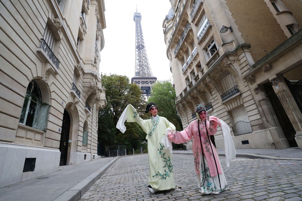 2023年9月13日，江蘇省演藝集團(tuán)昆劇院院長施夏明（左）和江蘇省演藝集團(tuán)昆劇院國家一級演員孔愛萍在法國巴黎埃菲爾鐵塔附近參加昆曲快閃。新華社記者 高靜 攝