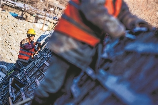 1月3日，房山區(qū)，工人正在雙泉河修筑堤壩。