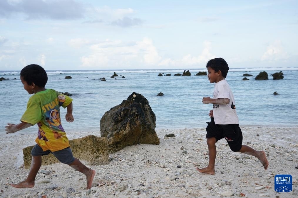 1月20日，兒童在瑙魯海邊嬉戲。新華社記者 王申 攝