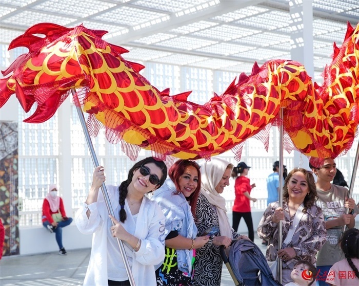 游客體驗(yàn)舞龍。 人民網(wǎng) 塔里克·易卜拉欣攝