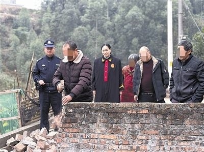  圖③：庭審結束后，在法官的見證下，陳某在院壩邊重新開鑿一條通道。