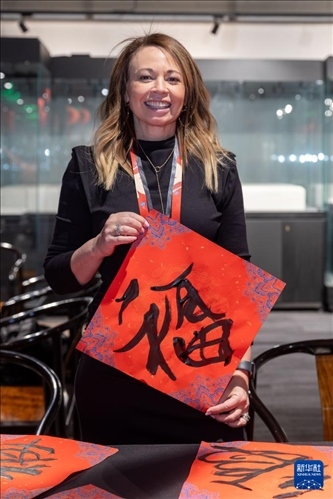 1月28日，在上海豫園舉行的民俗活動(dòng)上，美國(guó)馬斯卡廷初中校長(zhǎng)珍妮弗·李·弗里德利展示自己寫下的“?！弊?。 新華社記者 王翔 攝