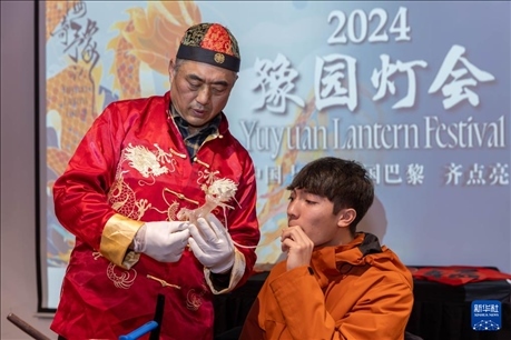 1月28日，在上海豫園舉行的民俗活動(dòng)上，美國(guó)馬斯卡廷中學(xué)學(xué)生在非遺傳承人的指導(dǎo)下吹糖偶。 新華社記者 王翔 攝