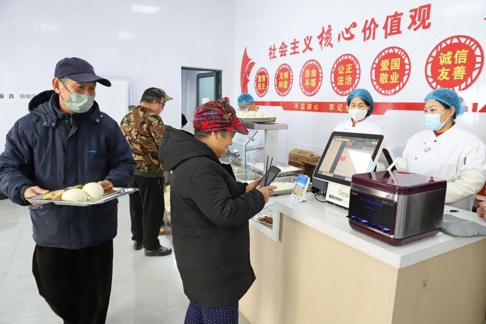 △2024年2月1日，市民在河北涿州市雙塔街道永濟秀園小區(qū)便民食堂內(nèi)購買午餐。