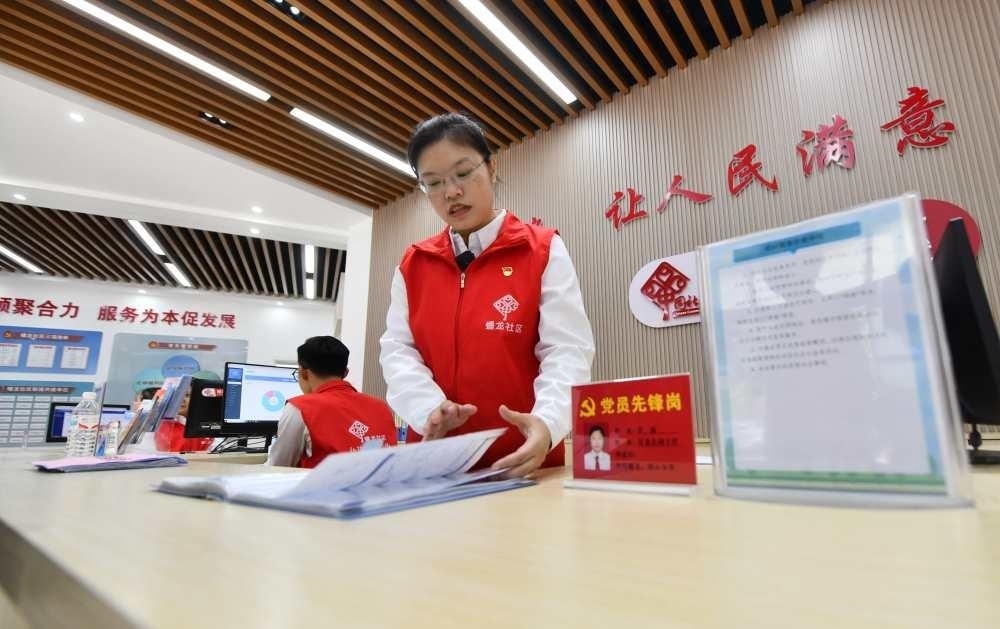 △2023年12月14日，廣西南寧市蟠龍社區(qū)，工作人員在為居民服務(wù)。