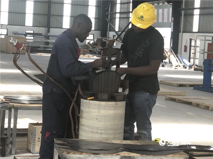 經(jīng)貿(mào)合作區(qū)廠房?jī)?nèi)，當(dāng)?shù)毓と苏诰o張作業(yè)。人民網(wǎng)記者 黃培昭攝