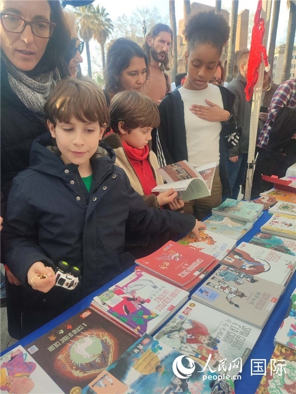 印刷精美的中國(guó)傳統(tǒng)文化叢書(shū)吸引了小游客的注意。人民網(wǎng)記者鄭彬攝