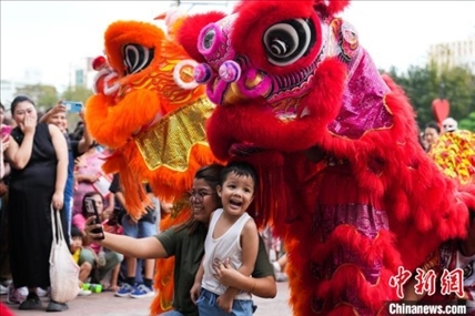 圖為舞獅表演吸引民眾合影。張興龍攝