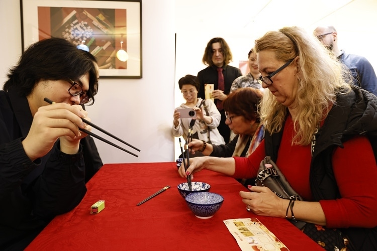 羅馬尼亞觀眾體驗(yàn)用筷子夾花生。中國文化中心供圖