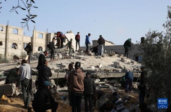  3月3日，在加沙地帶南部城市拉法，人們查看被以軍空襲破壞的建筑。新華社發(fā)（哈立德·奧馬爾攝）