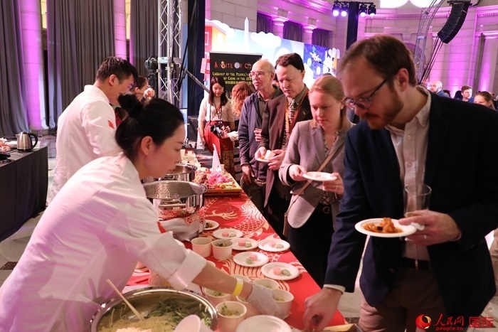 當(dāng)?shù)貢r間3月7日晚，華盛頓聯(lián)合車站廣場舉行駐美使團(tuán)“使館主廚挑戰(zhàn)賽”。圖為當(dāng)?shù)孛癖娫谥袊古_前體驗(yàn)中國美食。人民網(wǎng)記者 李志偉攝