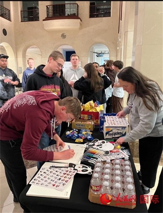 學生們出發(fā)前紛紛在留言簿留言。人民網記者 鄧圩攝