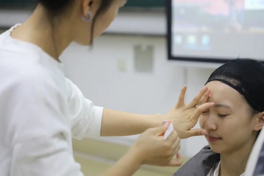 課堂上，一名學(xué)生在體驗(yàn)上戲妝。學(xué)校供圖