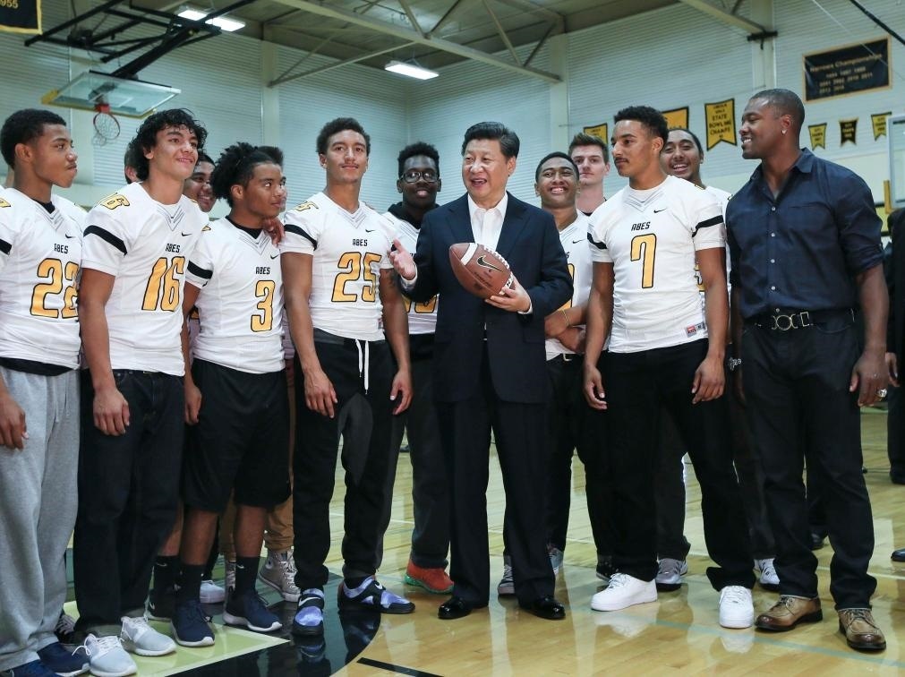 2015年9月23日，國家主席習(xí)近平參觀美國塔科馬市林肯中學(xué)。這是習(xí)近平在學(xué)校體育館，同上橄欖球訓(xùn)練課的學(xué)生們親切交談。新華社記者 蘭紅光 攝