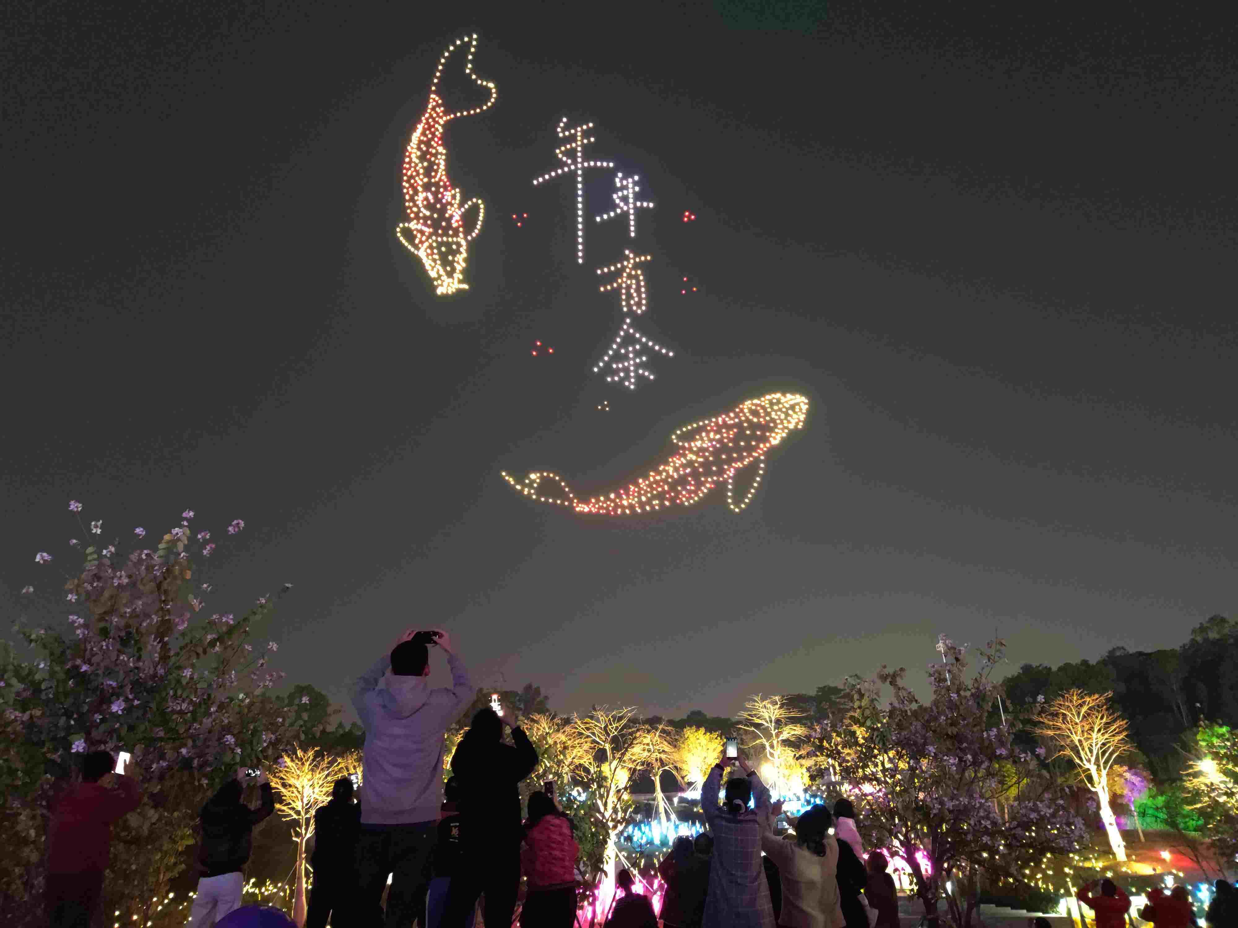 △ 2024年2月10日，深圳北站中心公園，春節(jié)主題無人機(jī)燈光秀引來眾多游客駐足觀看。