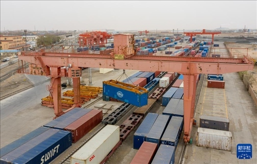 4月21日，二連浩特鐵路口岸龍門吊吊裝中歐班列集裝箱（無(wú)人機(jī)照片）。 新華社發(fā)（張海峰攝）