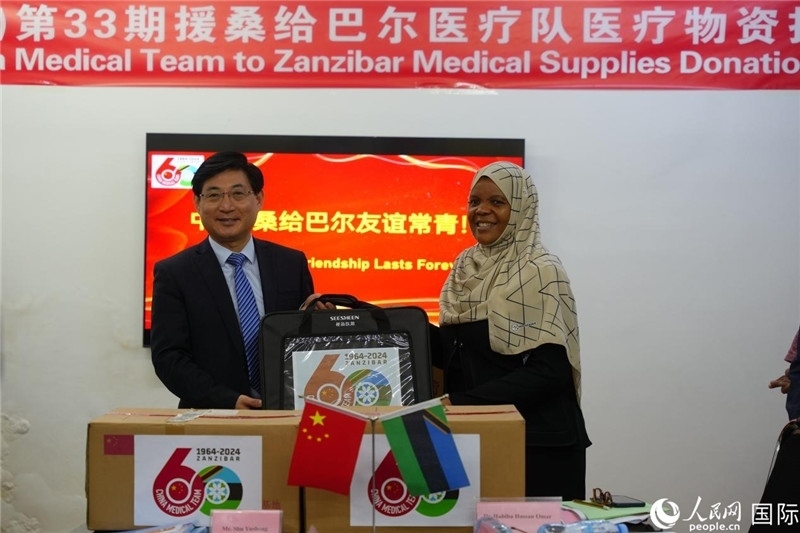 江蘇省蘇北人民醫(yī)院黨委書記束余聲捐贈物資與桑衛(wèi)生部首席秘書哈比巴。中國援桑醫(yī)療隊供圖