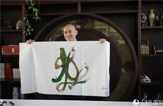 老撾駐華大使館三秘明君參加《五百筆·瀾湄合作》集體藝術(shù)創(chuàng)作。人民網(wǎng)王婧攝。