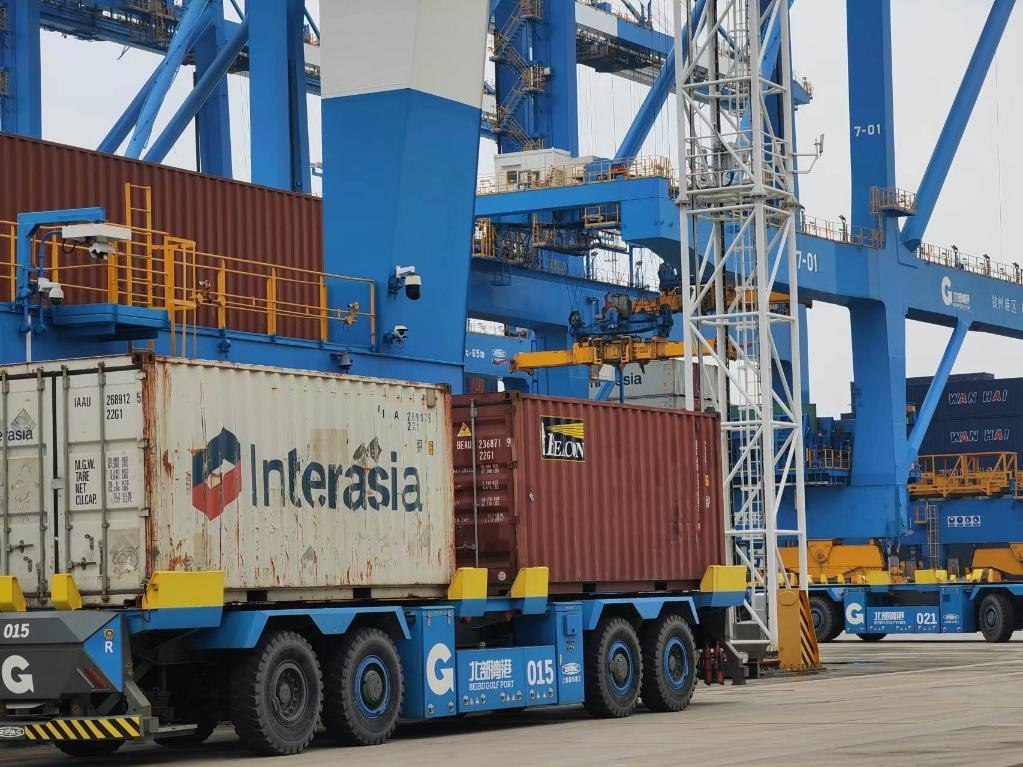 在欽州自動(dòng)化集裝箱碼頭，智能導(dǎo)引運(yùn)輸車在運(yùn)送集裝箱。新華社記者趙歡 攝