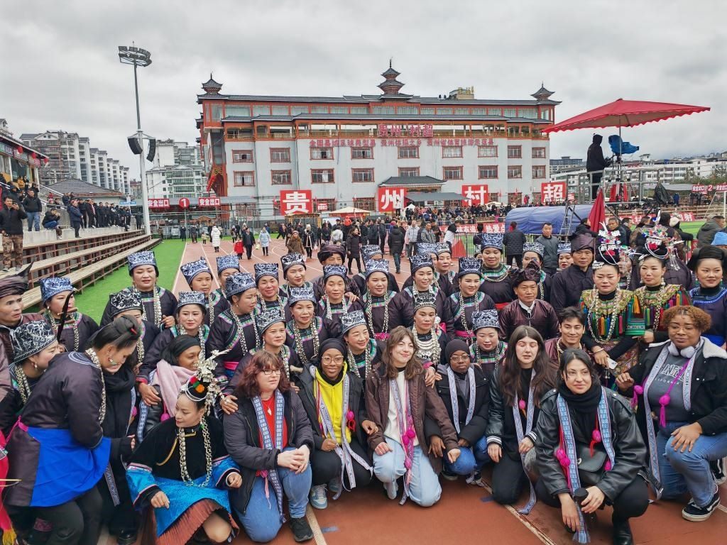 法國青年在“村超”賽場邊與參加表演的村民合影。新華社記者 羅羽 攝