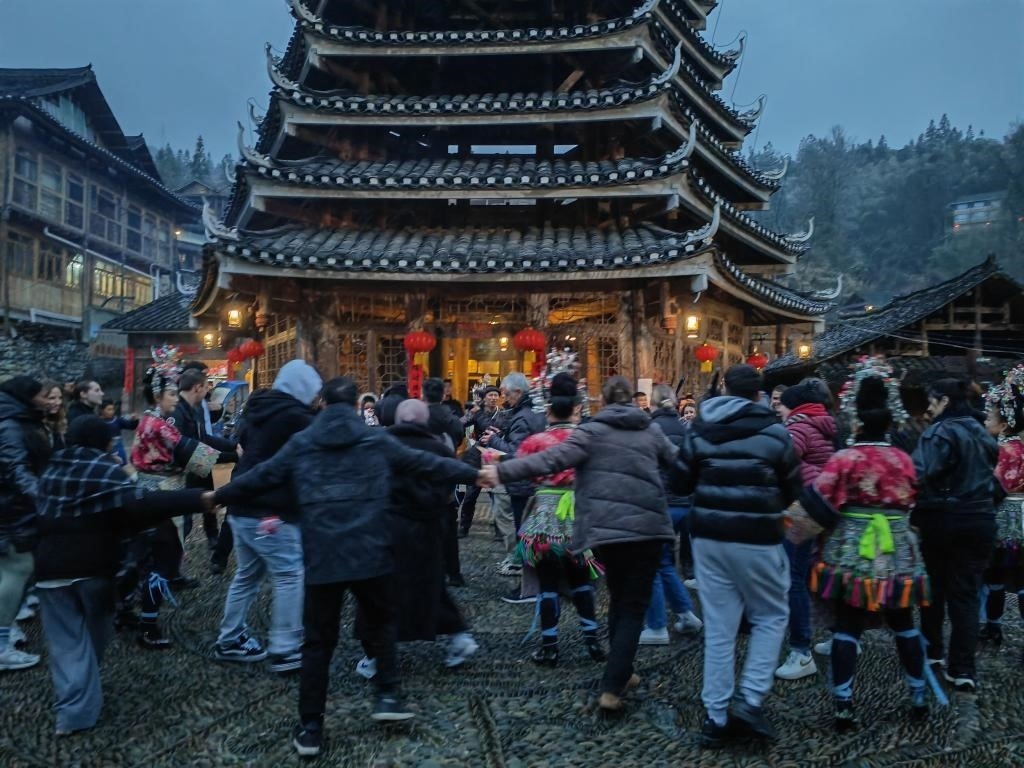 法國青年與當(dāng)?shù)卮迕駹渴痔?。新華社記者 羅羽 攝