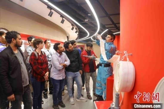 5月9日，工作人員指導(dǎo)留學(xué)生正確使用消防水帶。張鷹 攝