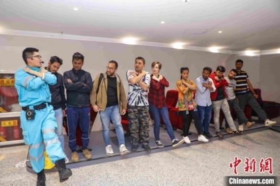 5月9日，工作人員指導(dǎo)留學(xué)生練習(xí)逃生技巧。張鷹 攝