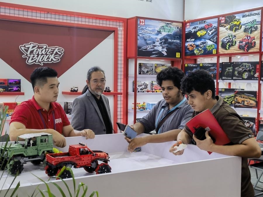 在第135屆廣交會(huì)第三期現(xiàn)場(chǎng)，采購(gòu)商在廣東信宇科技股份有限公司展位選購(gòu)、體驗(yàn)積木遙控車產(chǎn)品（5月2日攝）。新華社記者 洪澤華 攝