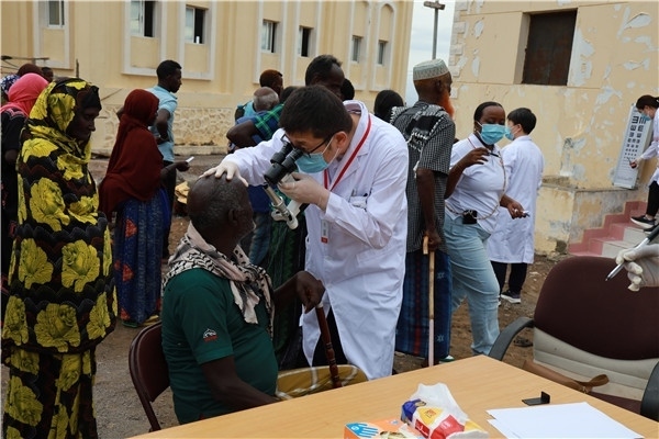 在義診現(xiàn)場(chǎng)，中國(guó)醫(yī)生與當(dāng)?shù)鼐用窈嫌傲裟?，吉布提鹽業(yè)投資公司供圖