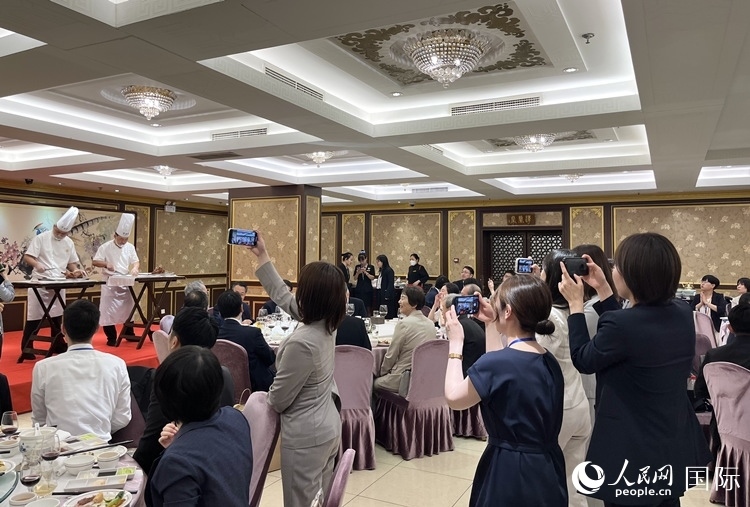 國(guó)家級(jí)非物質(zhì)文化遺產(chǎn)、全聚德片鴨工藝吸引代表團(tuán)成員拍照留念。