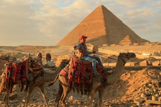 1月24日，商販騎駱駝離開埃及吉薩金字塔景區(qū)。新華社記者 隋先凱 攝