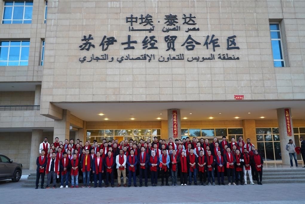 2024年2月11日，在位于埃及蘇伊士省的中?！ぬ┻_蘇伊士經(jīng)貿(mào)合作區(qū)，中埃員工在合作區(qū)辦公大樓前合影拜年。新華社發(fā)（泰達合作區(qū)供圖）