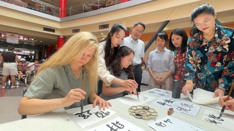 羅馬尼亞友人在活動(dòng)現(xiàn)場學(xué)寫漢字。中國駐羅馬尼亞大使館領(lǐng)僑處供圖
