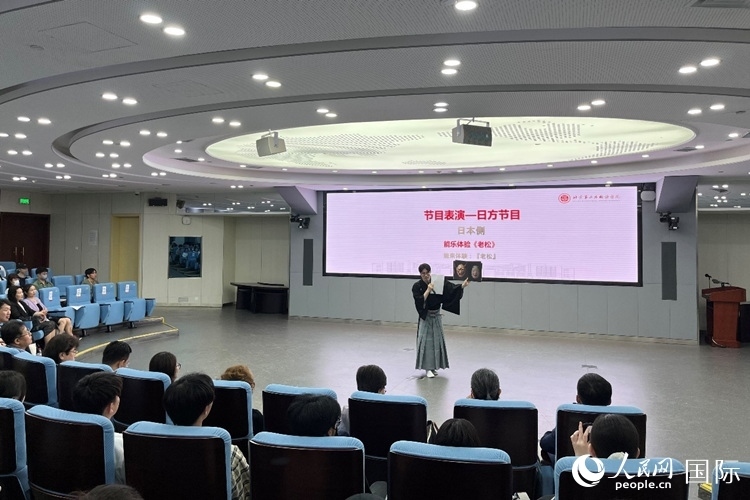 日本大學(xué)生介紹能樂知識。人民網(wǎng)記者 陳思攝