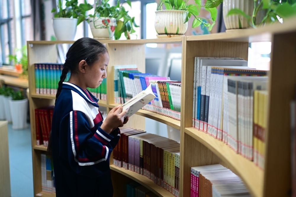 6月18日，果洛西寧民族中學(xué)學(xué)生尼東拉毛在圖書室看書。