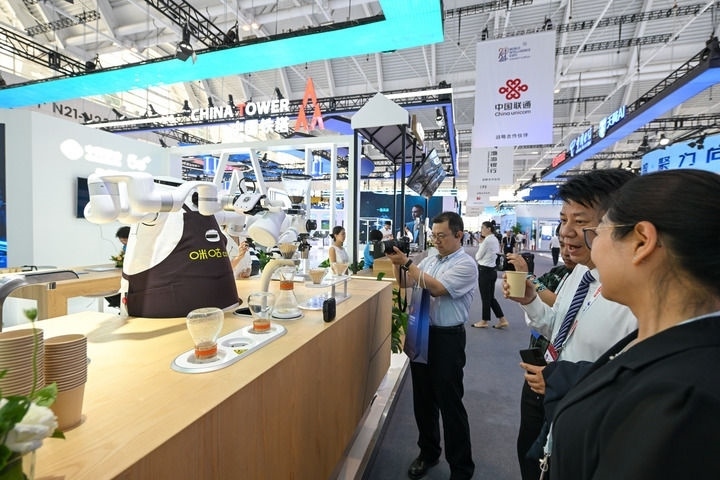 6月20日，與會者品嘗機器人沖調(diào)出的咖啡。新華社記者 孫凡越 攝