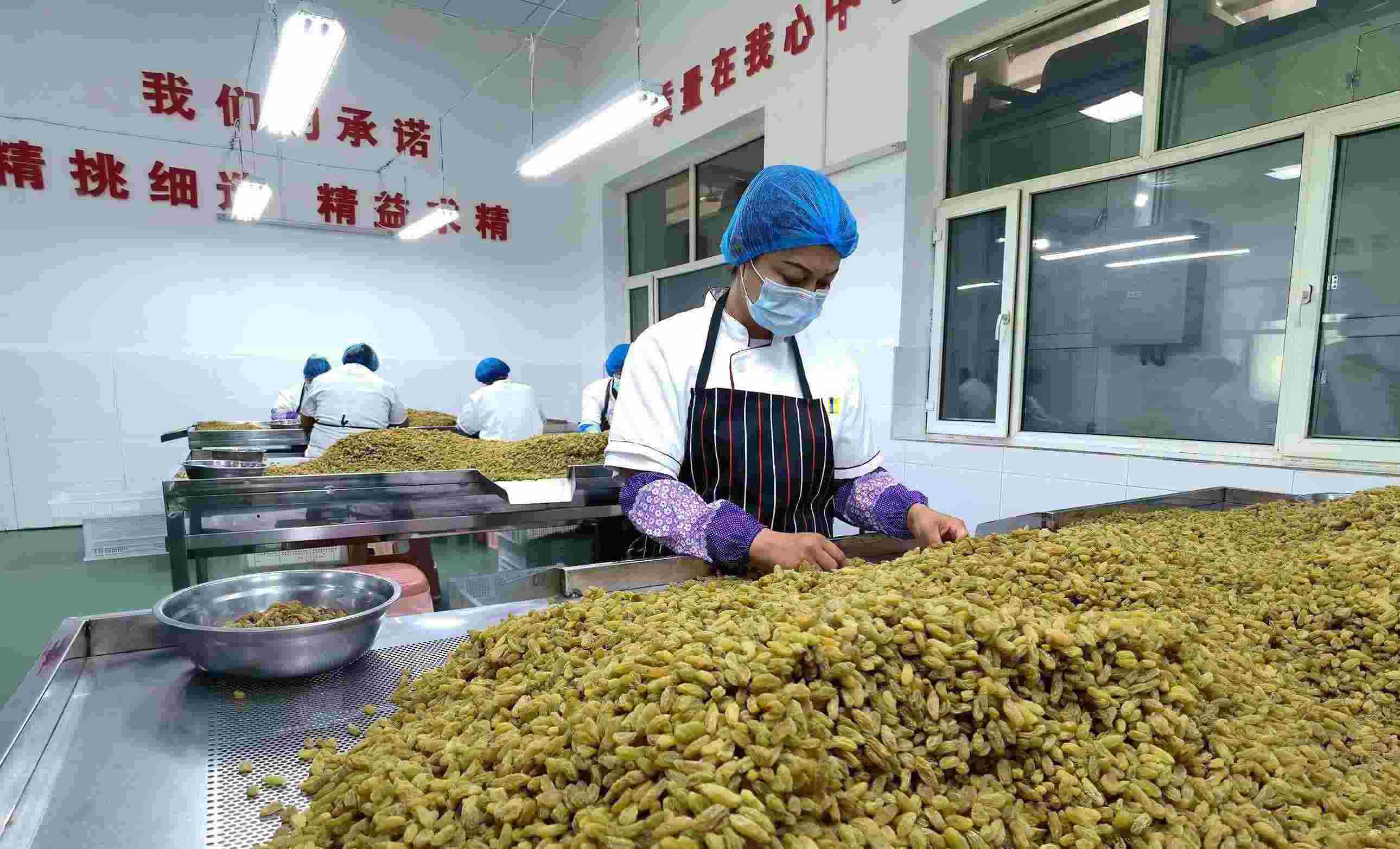 新疆吐魯番市高昌區(qū)亞爾鎮(zhèn)新城西門村，村民們在分揀葡萄干。