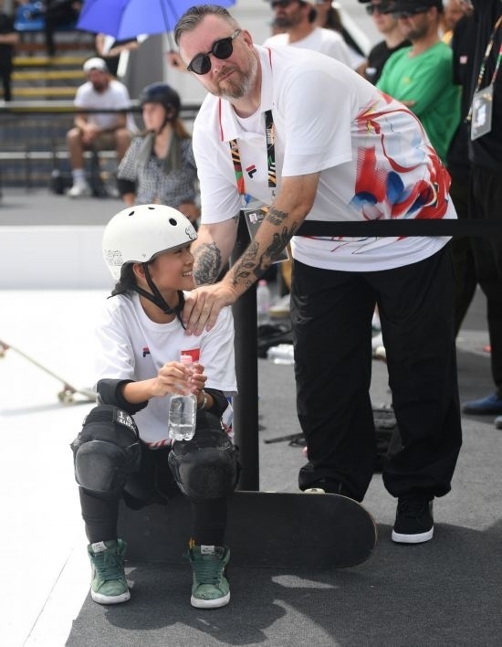 6月20日，鄭好好（左）在比賽間隙與教練互動，她在預賽中最佳成績?yōu)?2.60分。當日，巴黎奧運會資格系列賽布達佩斯站滑板女子碗池預賽在布達佩斯舉行。新華社記者 賀燦鈴 攝