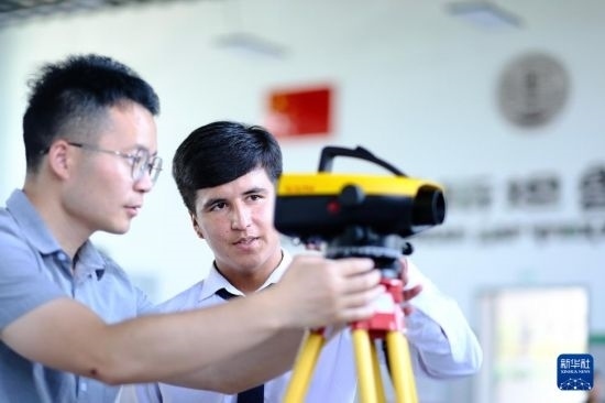 6月14日，在塔吉克斯坦首都杜尚別的魯班工坊，來(lái)自天津城市建設(shè)管理職業(yè)技術(shù)學(xué)院的老師（左）指導(dǎo)學(xué)生。新華社記者 鄭開(kāi)君 攝