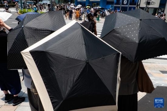 7月4日，人們在日本東京原宿的街道上等待紅綠燈。新華社記者 張笑宇 攝