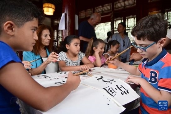 7月4日，在馬耳他桑塔露琪亞市的中國古典園林“靜園”，人們體驗中國書法。新華社發(fā)（喬納森·博格 攝）