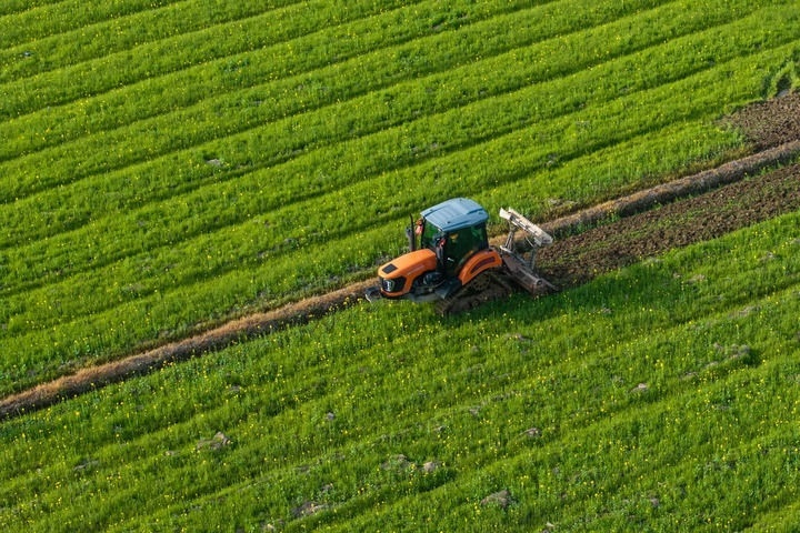 2024年3月19日，在湖南省常德市鼎城區(qū)謝家鋪鎮(zhèn)港中坪村，村民駕駛農(nóng)機翻耕田地（無人機照片）。新華社記者 陳思汗 攝