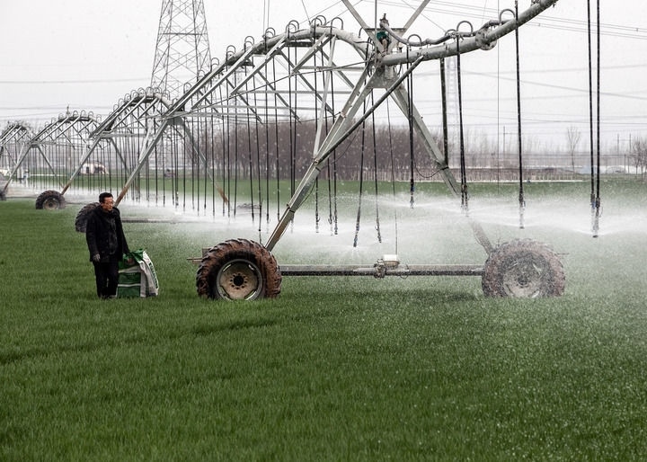 2024年3月18日，在河南省焦作市博愛縣孝敬鎮(zhèn)東原莊村瑞輝家庭農(nóng)場，村民使用全自動指針式噴灌機進行澆灌作業(yè)。新華社發(fā)（程全攝）
